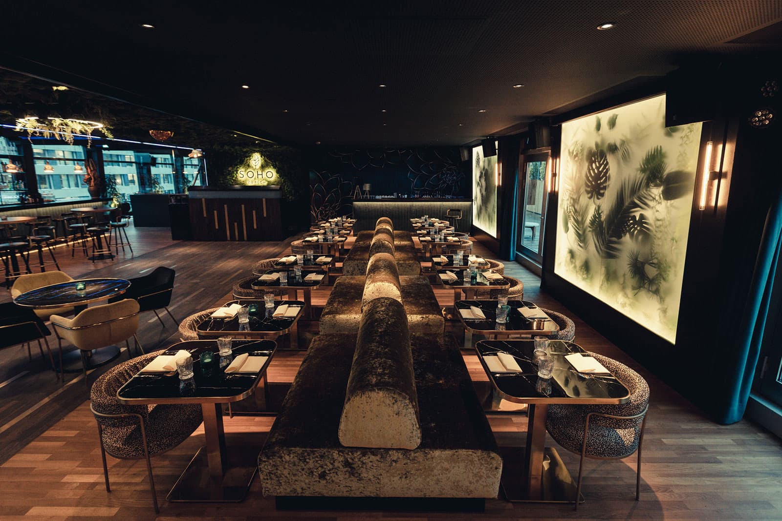 Soho Zürich's dining room with a backlit botanical wall and rooftop skyline, curated by Meetz