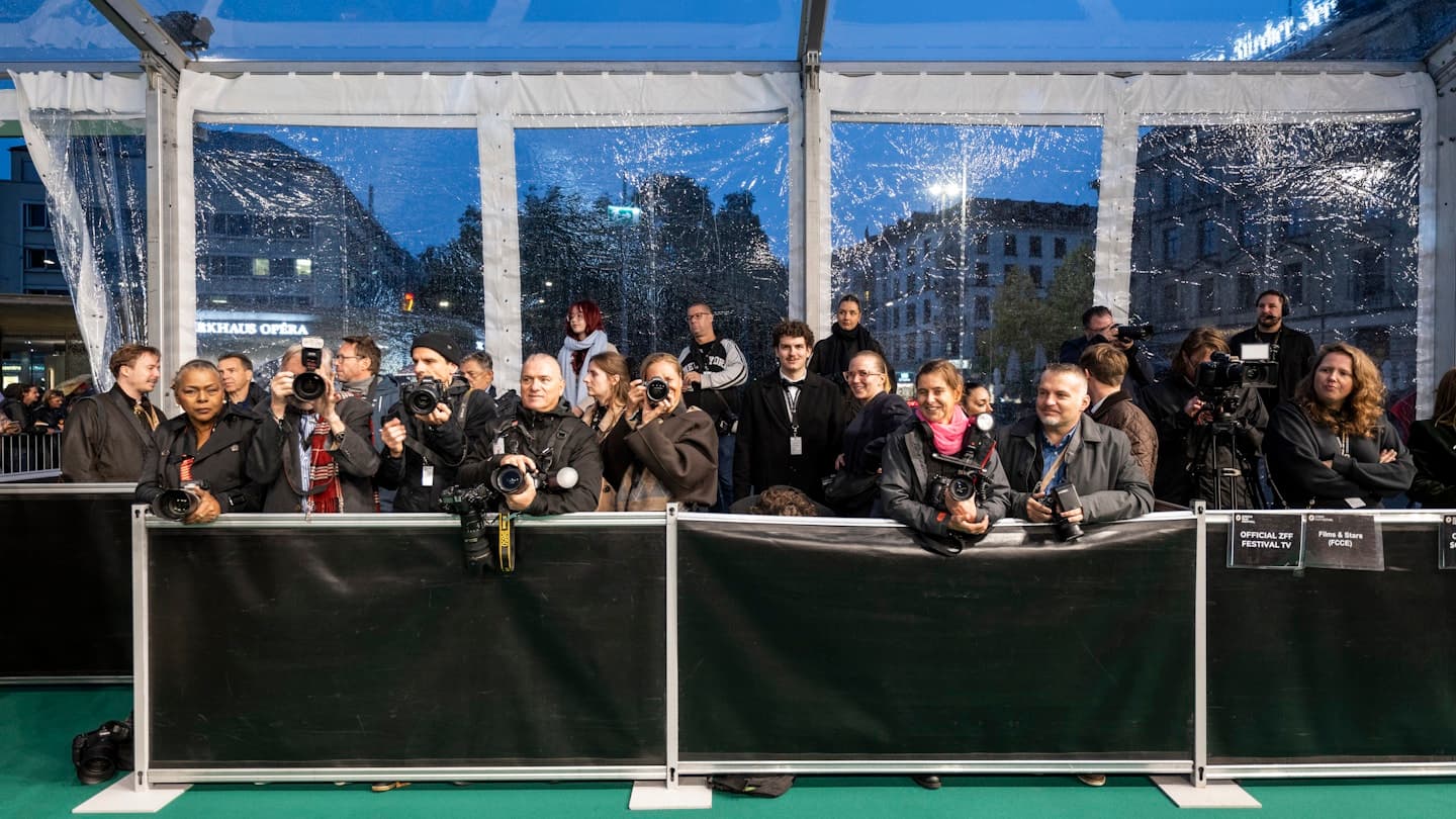 Press photographers behind the barrier on the green carpet