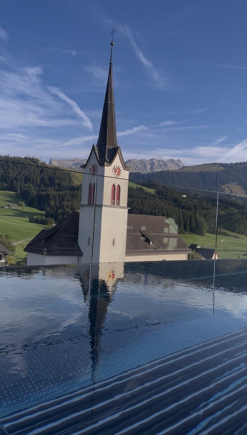 The village church reflected in the rooftop pool