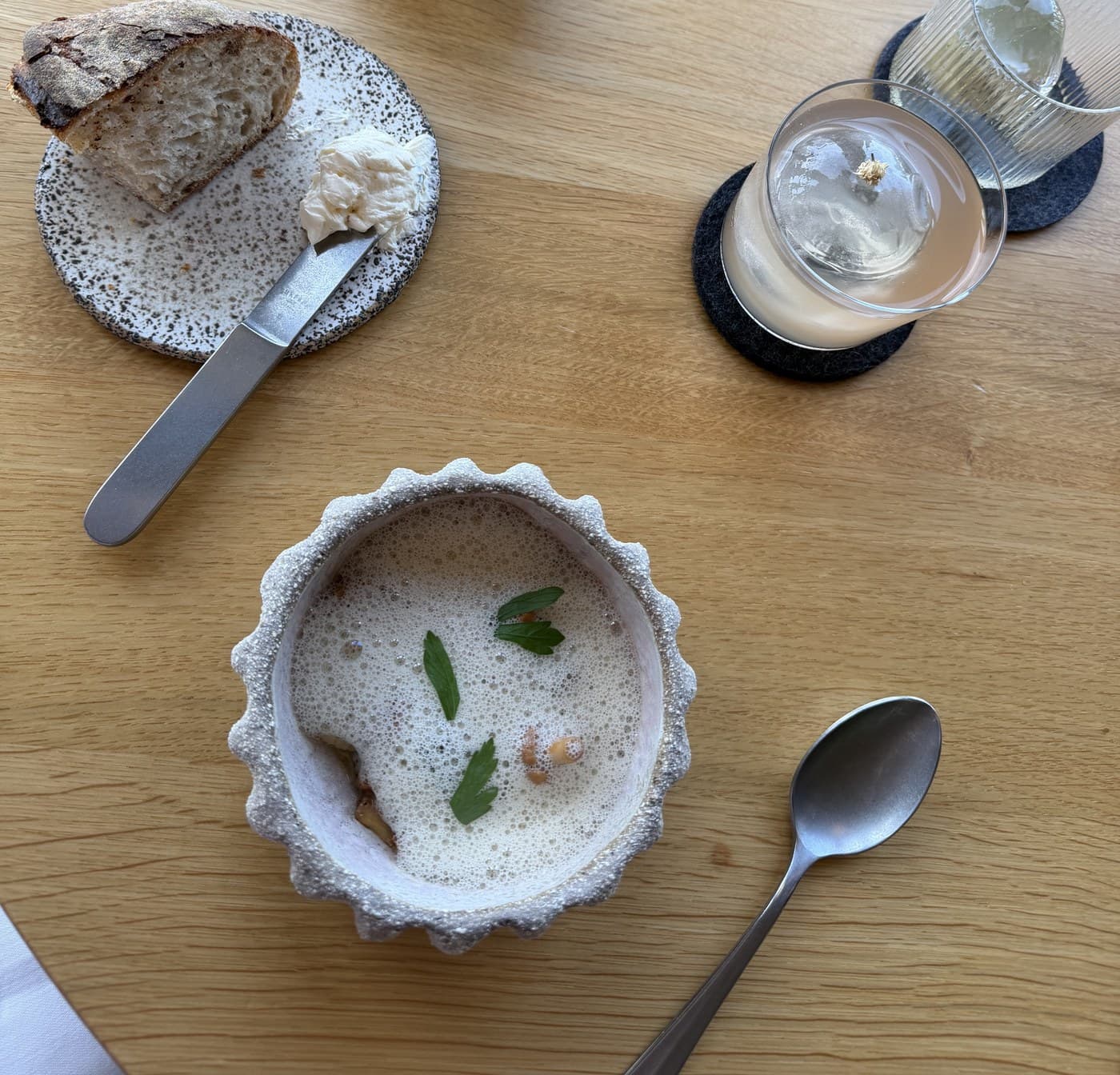 A tasting-menu course with a herb-and-mushroom broth