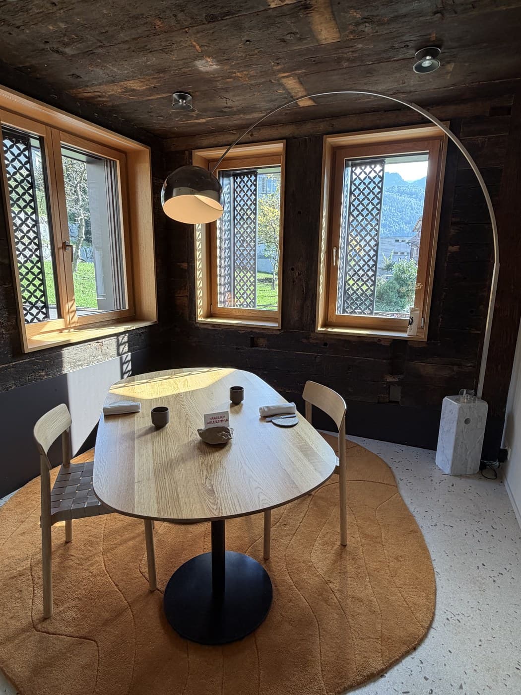 Corner table at Magdalena, original dark timber against pale oak furniture and lattice windows